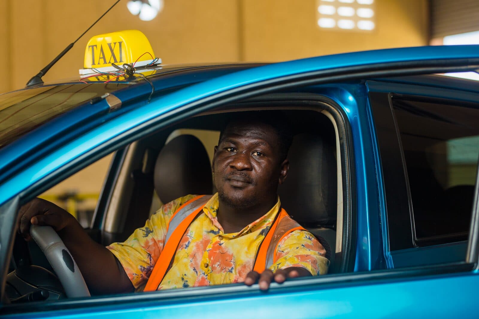 Un chauffeur de taxi souriant au volant de sa voiture